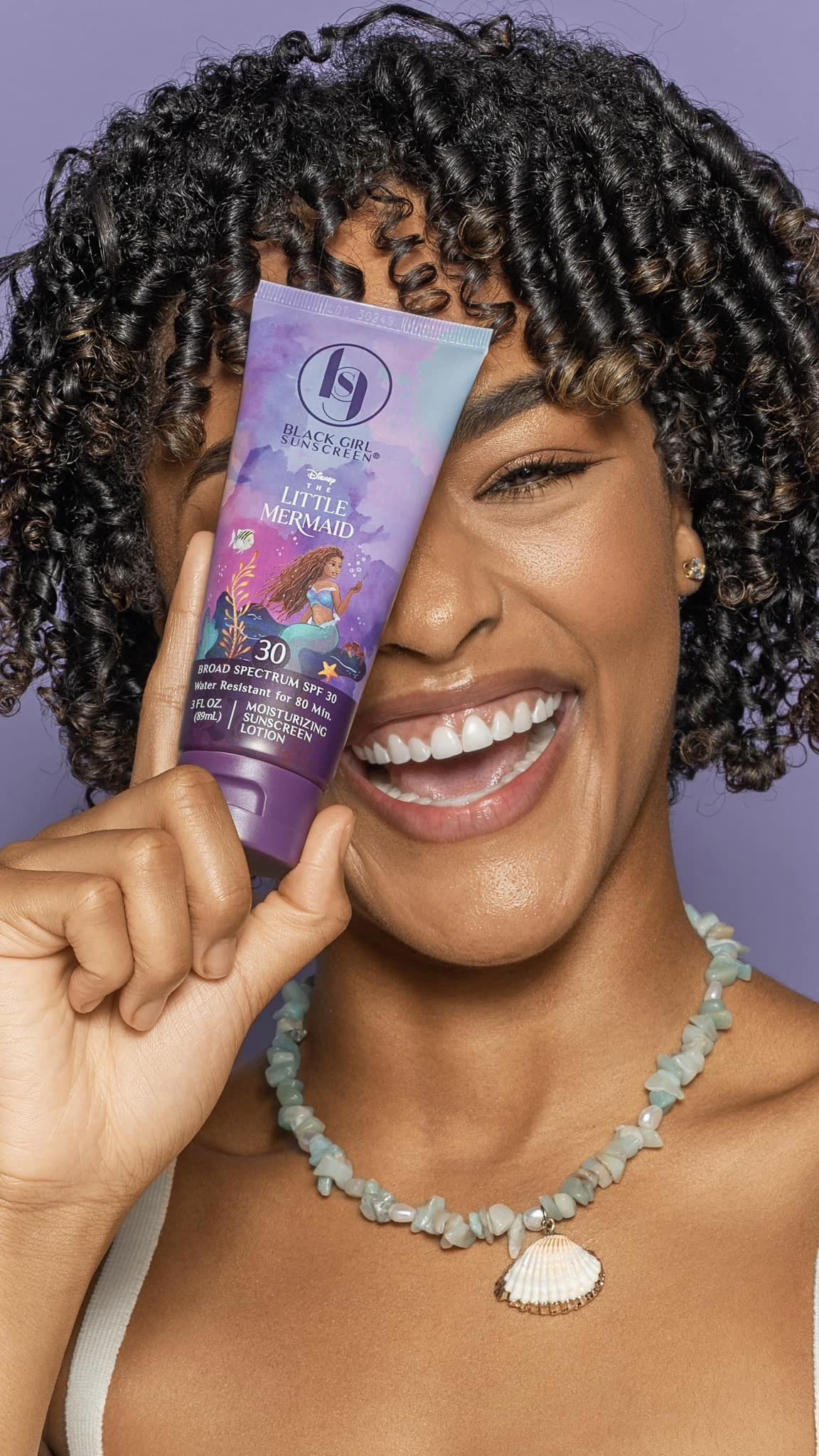 black girl sunscreen little mermaid product shoot with girl holding sunscreen lotion